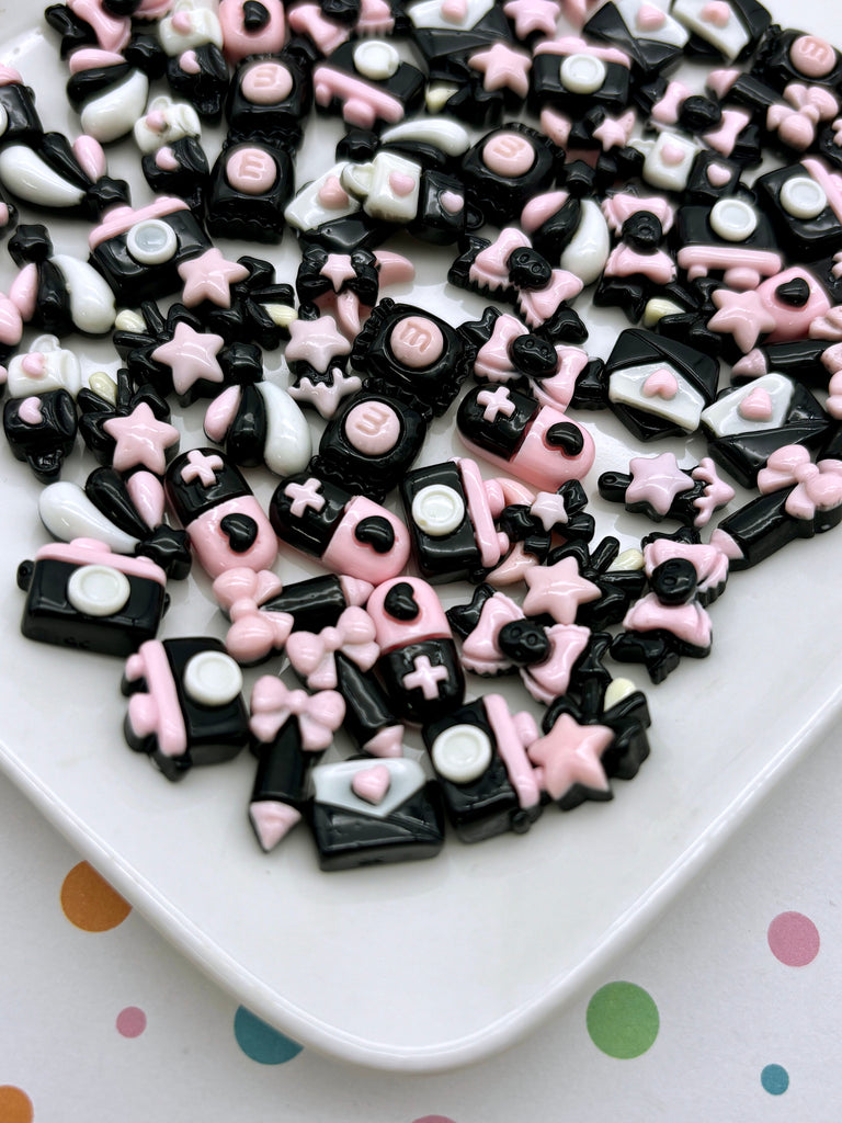 a white plate topped with lots of black and pink candies