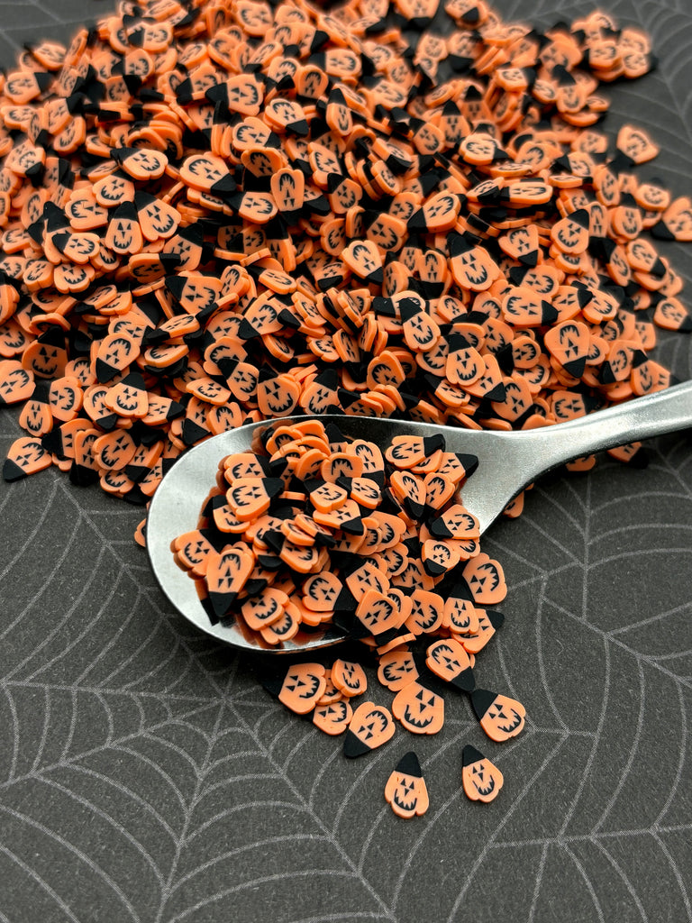 a spoon full of halloween buttons sitting on a table