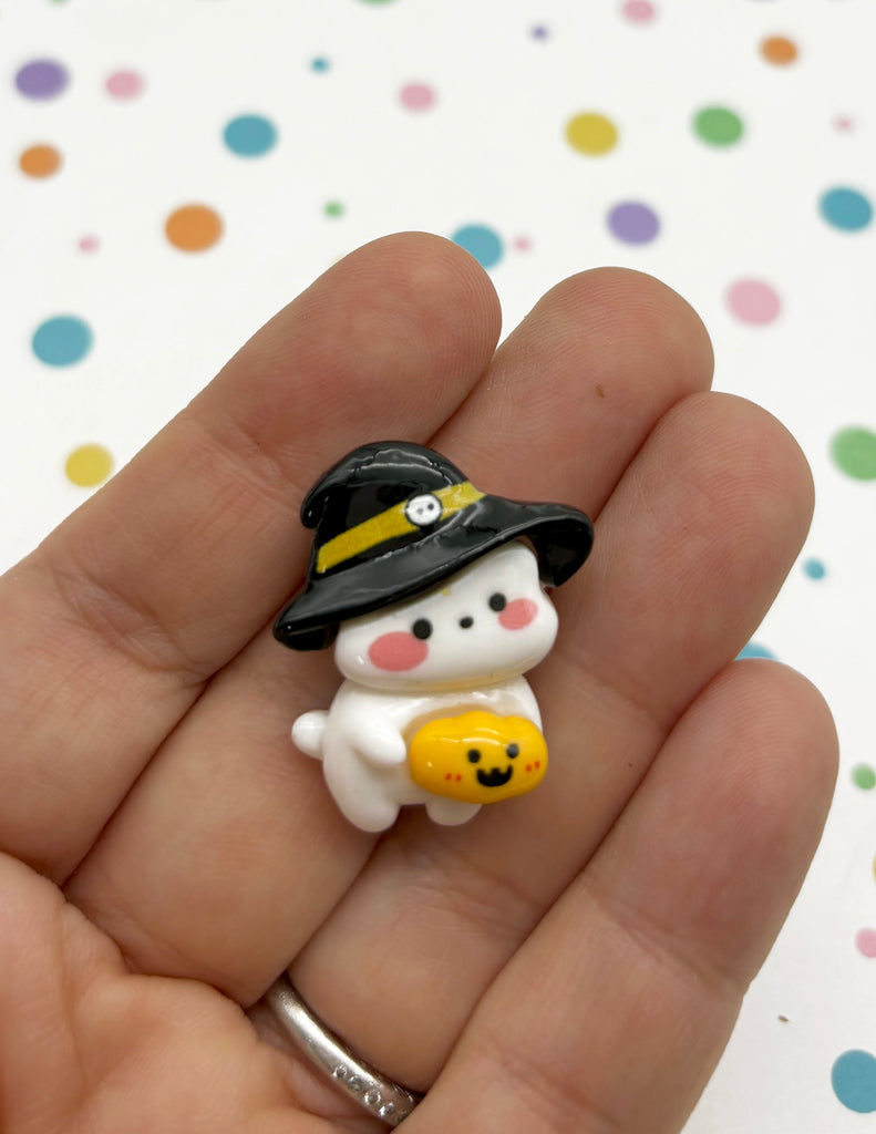 a hand holding a tiny toy animal wearing a hat