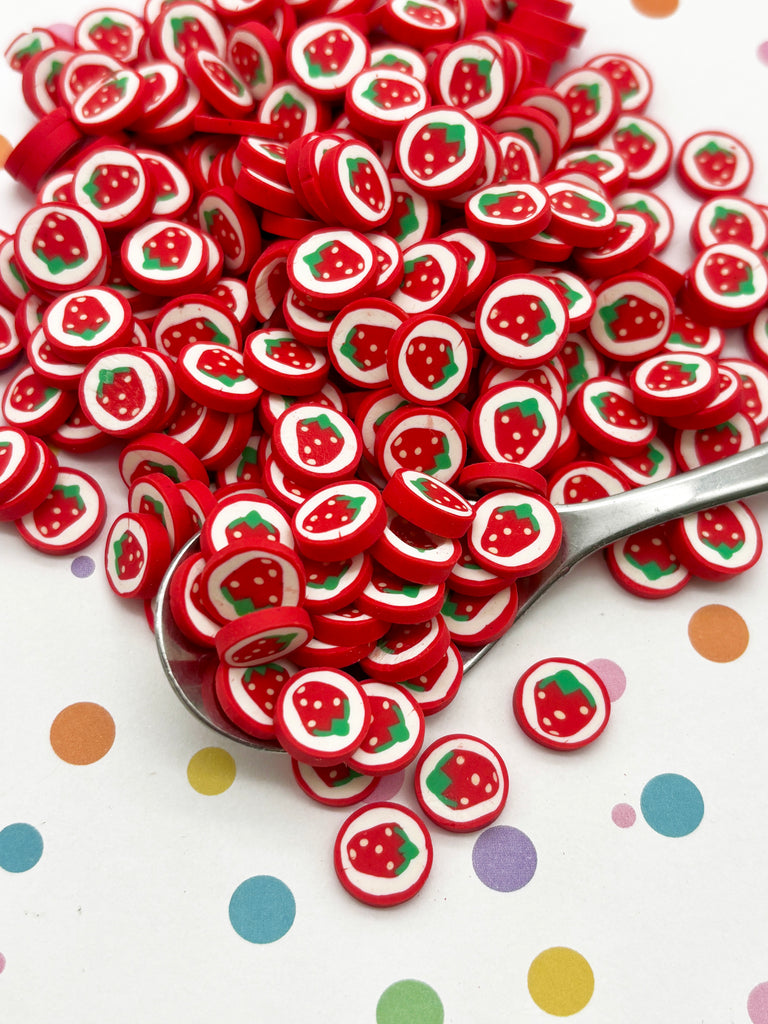 a spoon full of red and white strawberry buttons