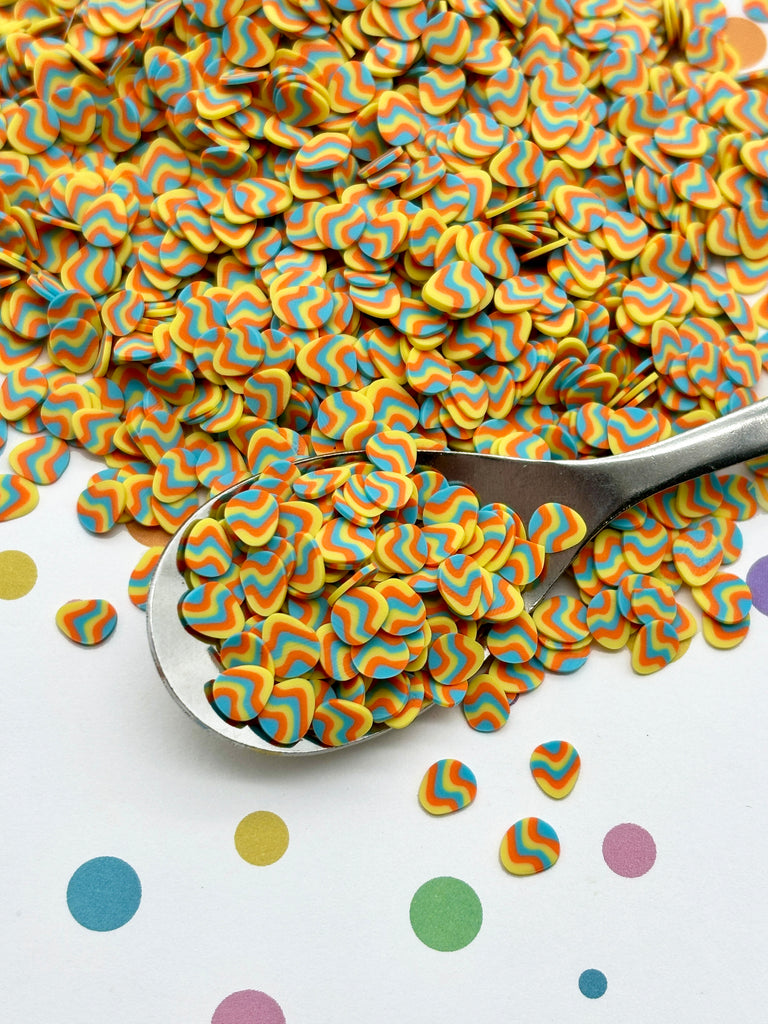 a spoon full of colorful confetti sitting on top of a table