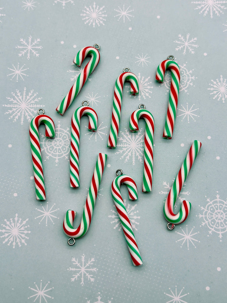 a collection of candy canes in various colors, including red, green, and white, arranged on a light blue background with white snowflakes.
