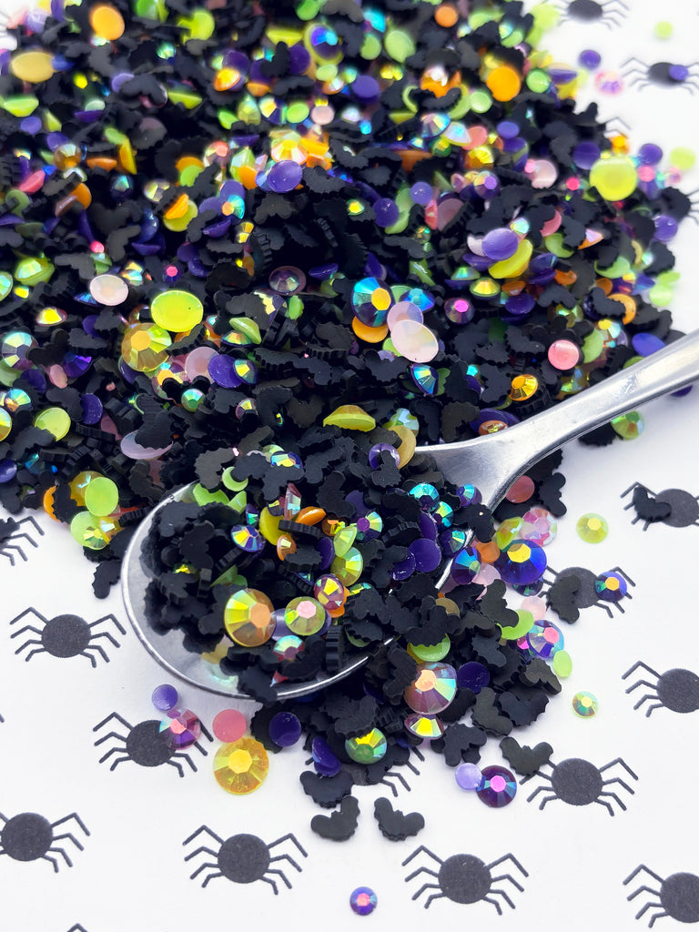 a spoon filled with black sprinkles on top of a table