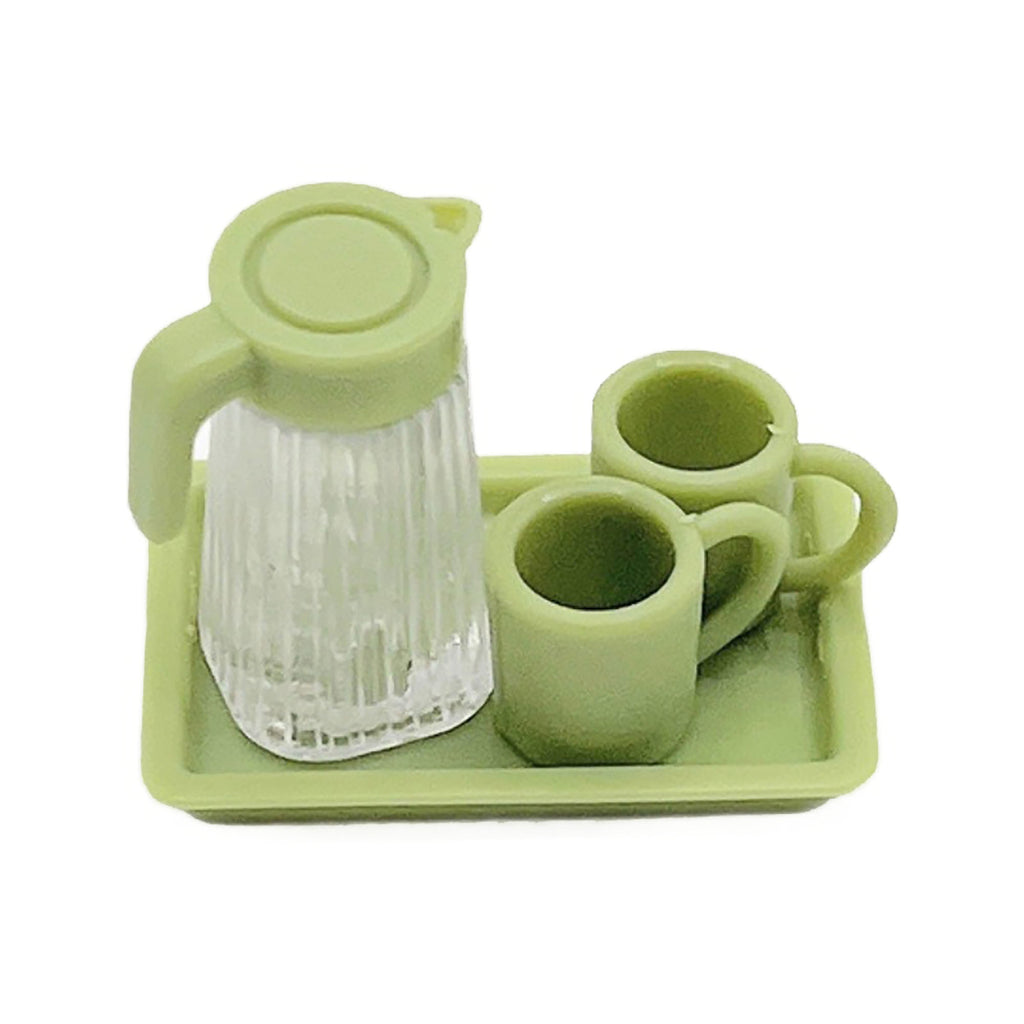 A green pitcher and two matching green cups are arranged on a green tray.