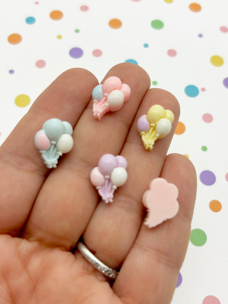 a person's hand holding a small assortment of miniature toys