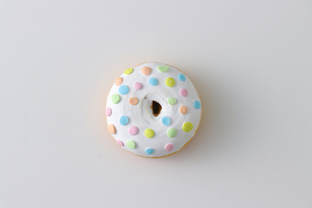 a white frosted donut with multicolored sprinkles