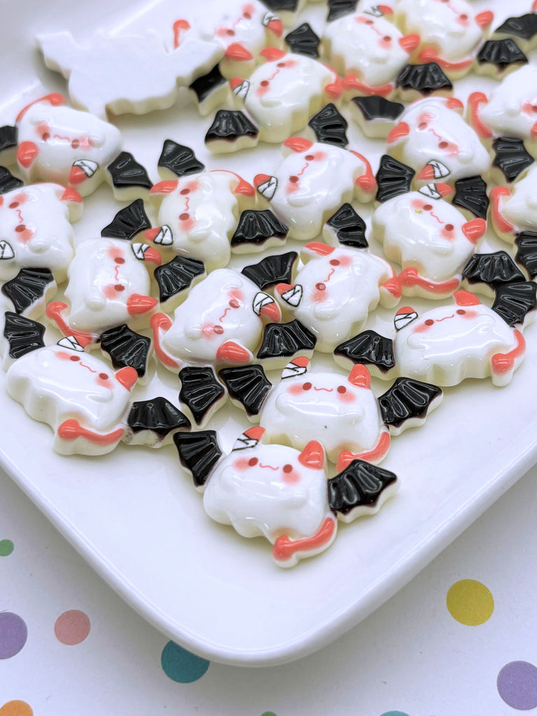 a white plate topped with lots of halloween cookies