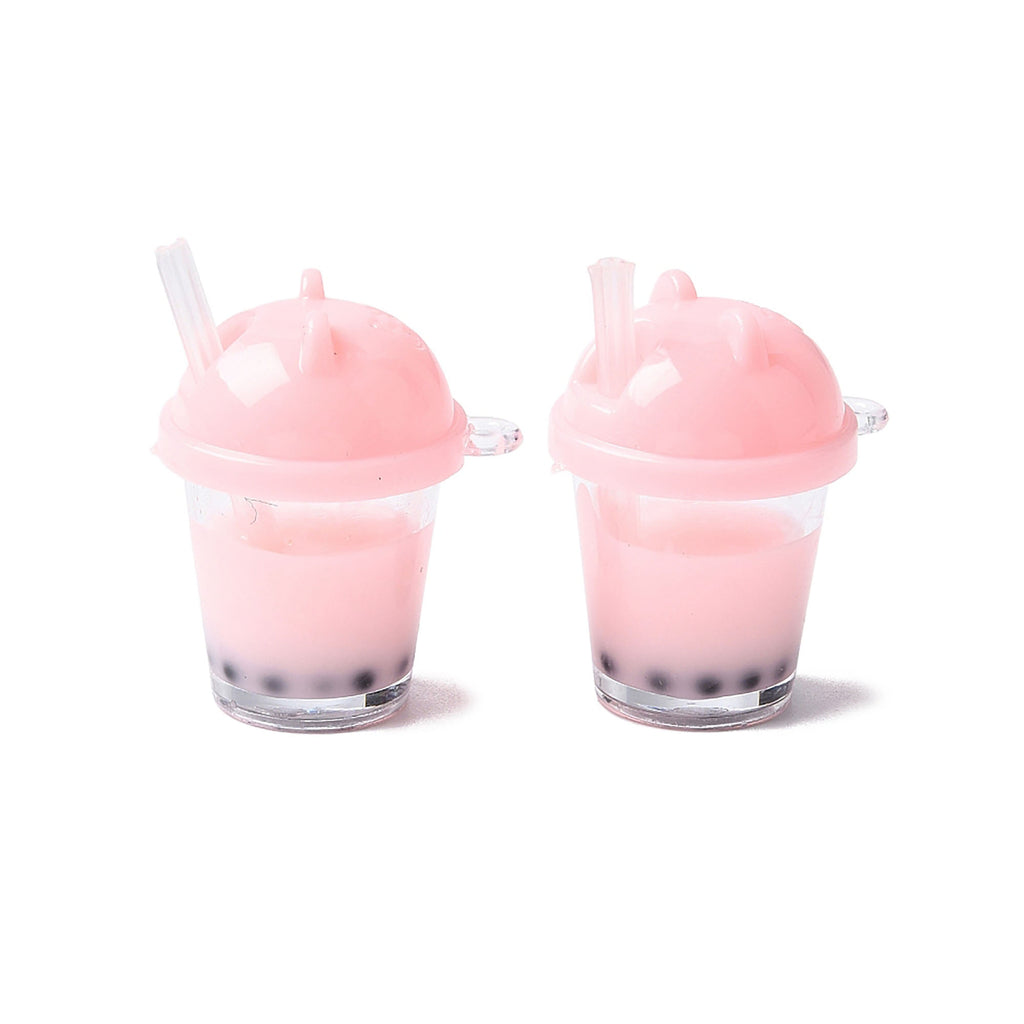 Two small pink cups with straws, each containing a pink liquid and topped with a clear lid.