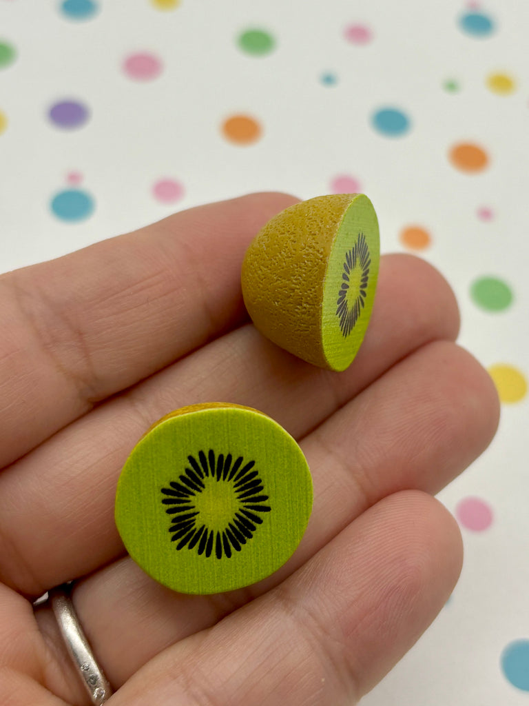 a person holding a green button with a kiwi on it