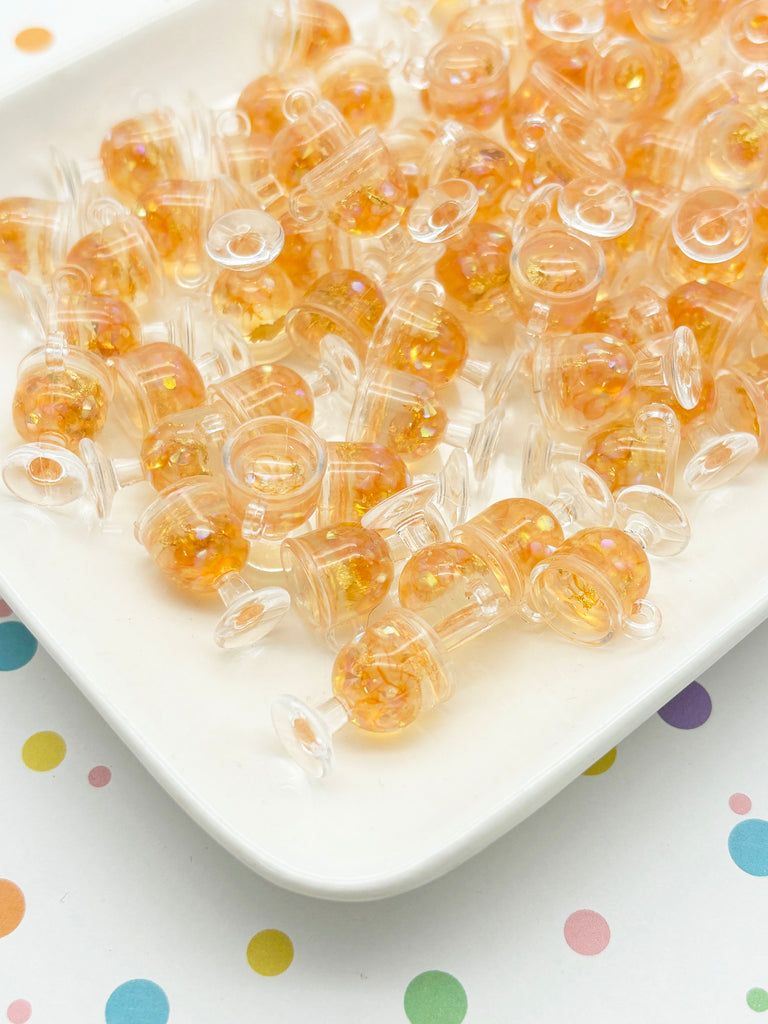 a white plate topped with lots of yellow beads