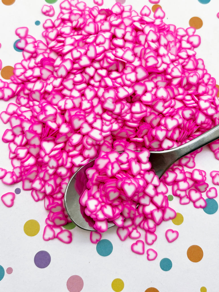 a pile of pink hearts sitting on top of a table