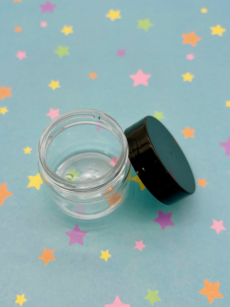 a clear jar with a black lid sitting on a blue surface