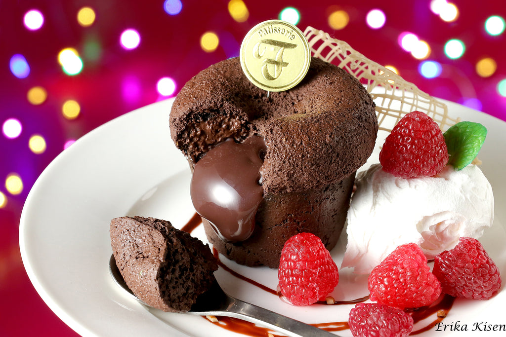 a piece of chocolate cake on a plate with raspberries