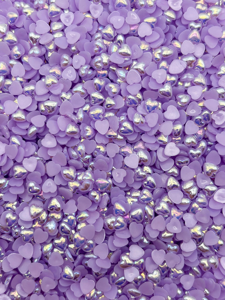 a pile of shiny purple buttons on top of a table