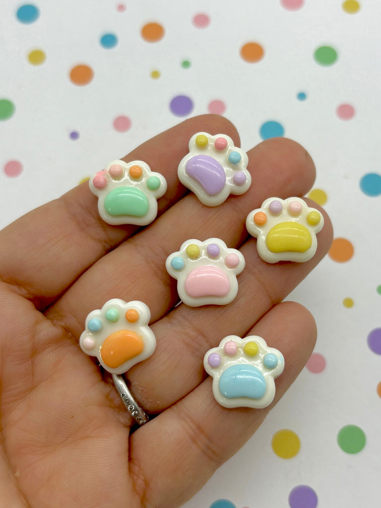 a hand holding a small set of tiny animal charms