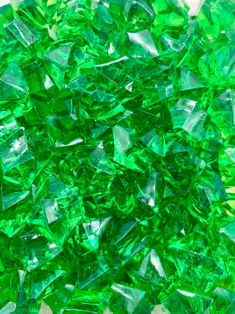 a pile of green glass blocks sitting on top of a table