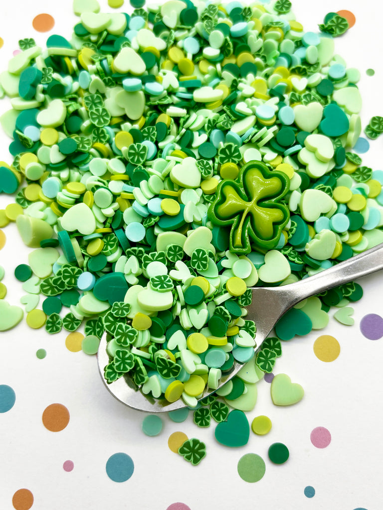 a spoon filled with green and white confetti