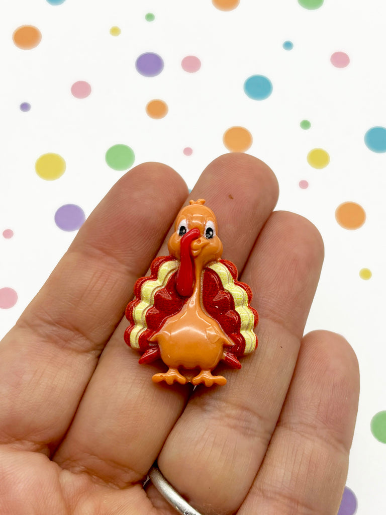 a hand holding a small toy turkey on it's palm