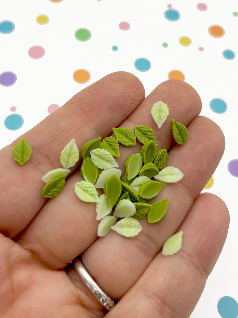 a hand holding a handful of green leaves