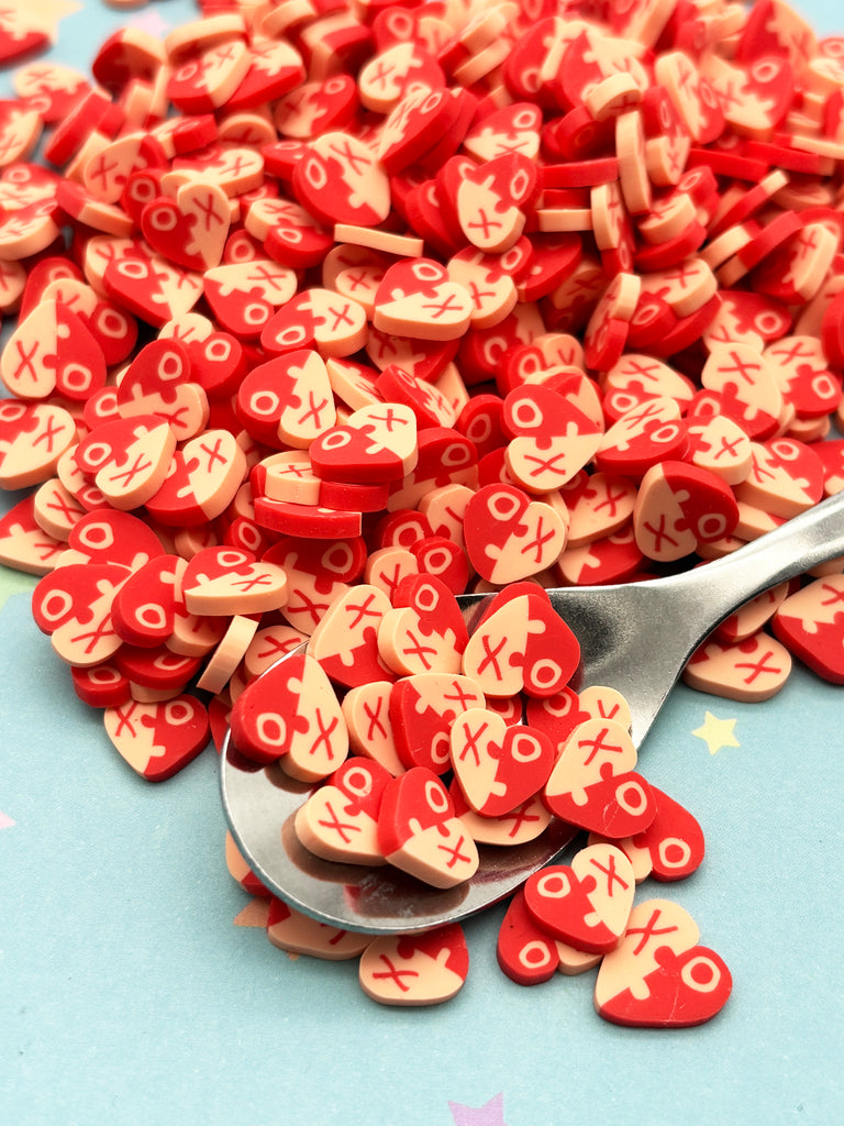 a spoon full of red and white heart shaped buttons