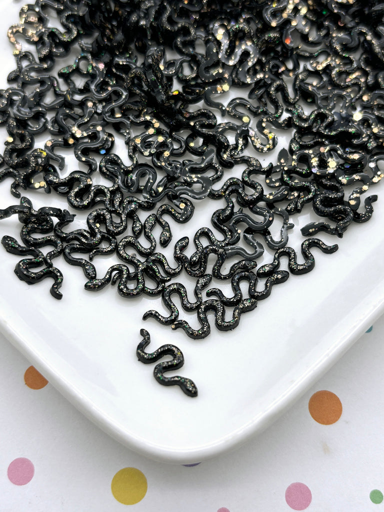 a white plate topped with lots of black beads