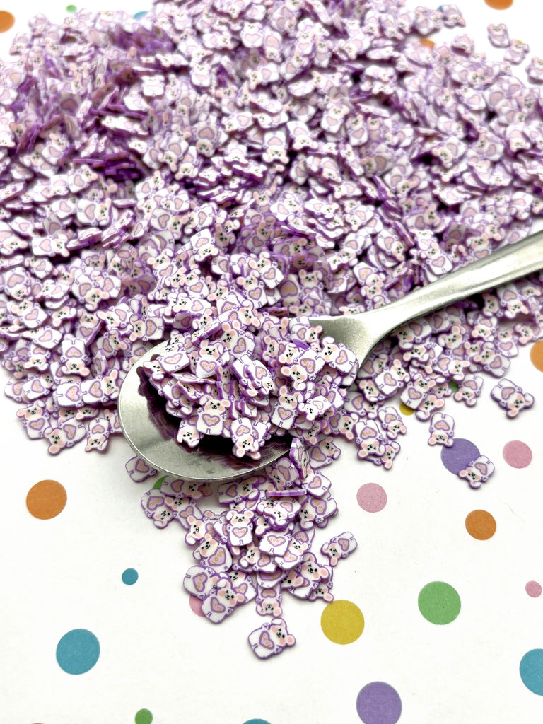 a spoon full of purple sprinkles on a polka dot tablecloth