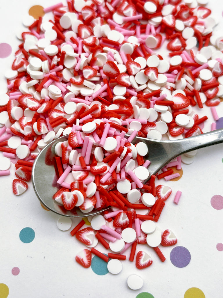 a spoon filled with red and white sprinkles