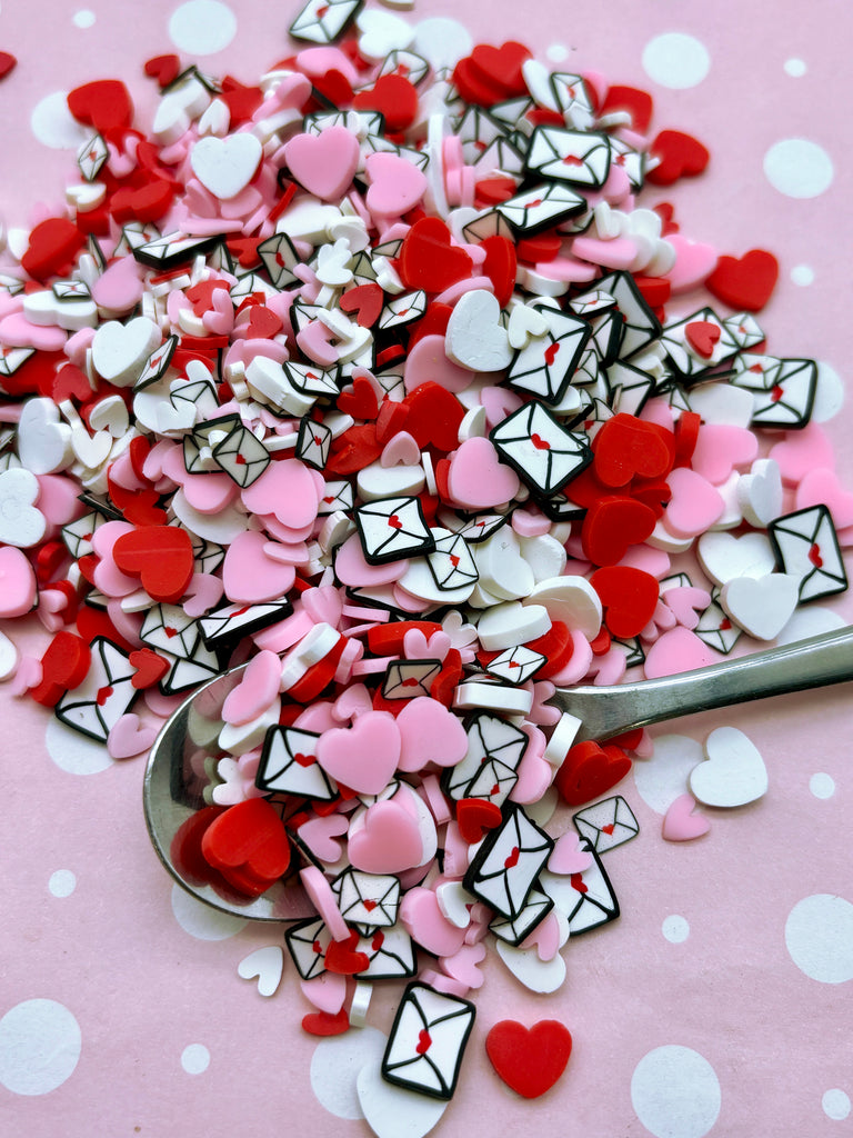 a spoon filled with lots of pink and white hearts