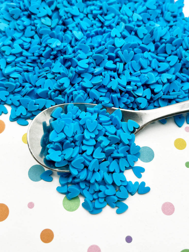 a spoon filled with blue sprinkles on top of a table