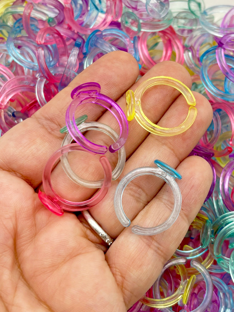 A hand holding a collection of colorful plastic rings against a background of similar rings.
