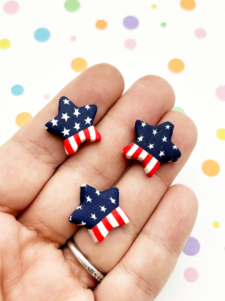 A hand holding three star-shaped objects with an American flag design, against a background of colorful polka dots.