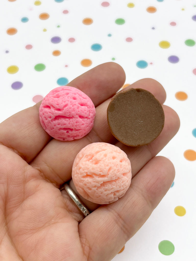 a person is holding two different colored doughnuts