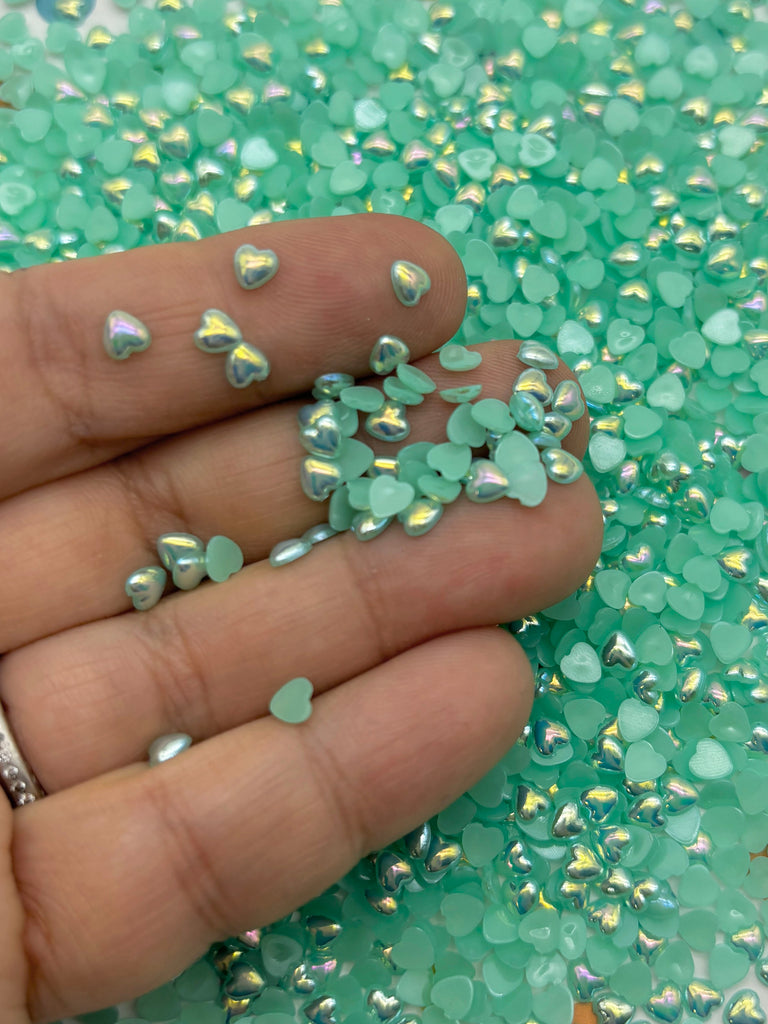 a hand holding a handful of green and silver confetti