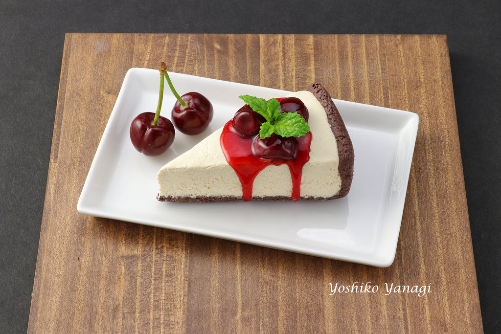 a piece of cheesecake with cherries on a plate