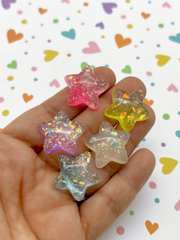 a hand holding five small stars in different colors