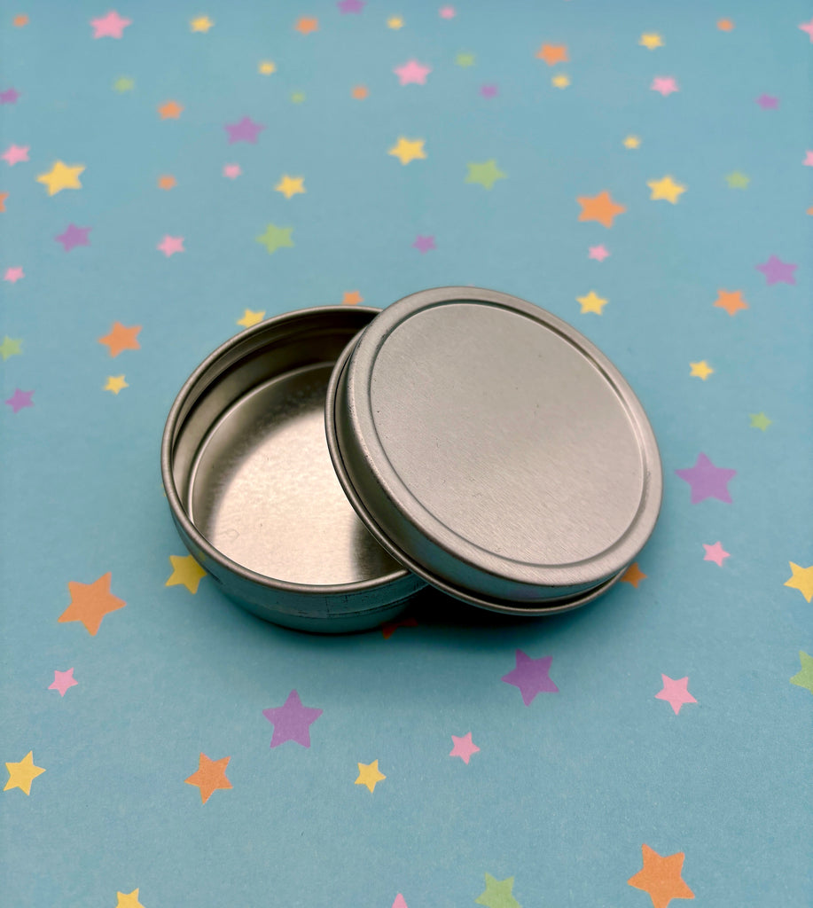 two tins sitting on top of a table covered in stars