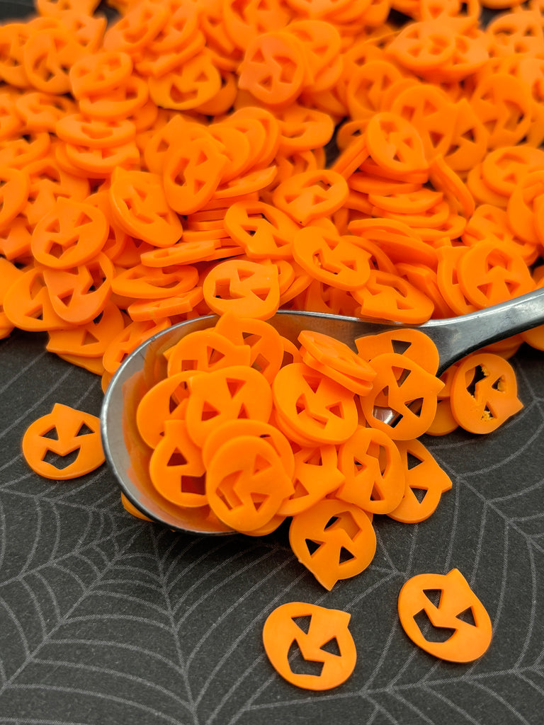 a spoon full of orange plastic letters on a table