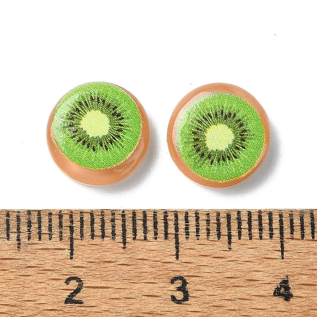 two kiwi fruit-shaped objects placed next to a ruler for size comparison.
