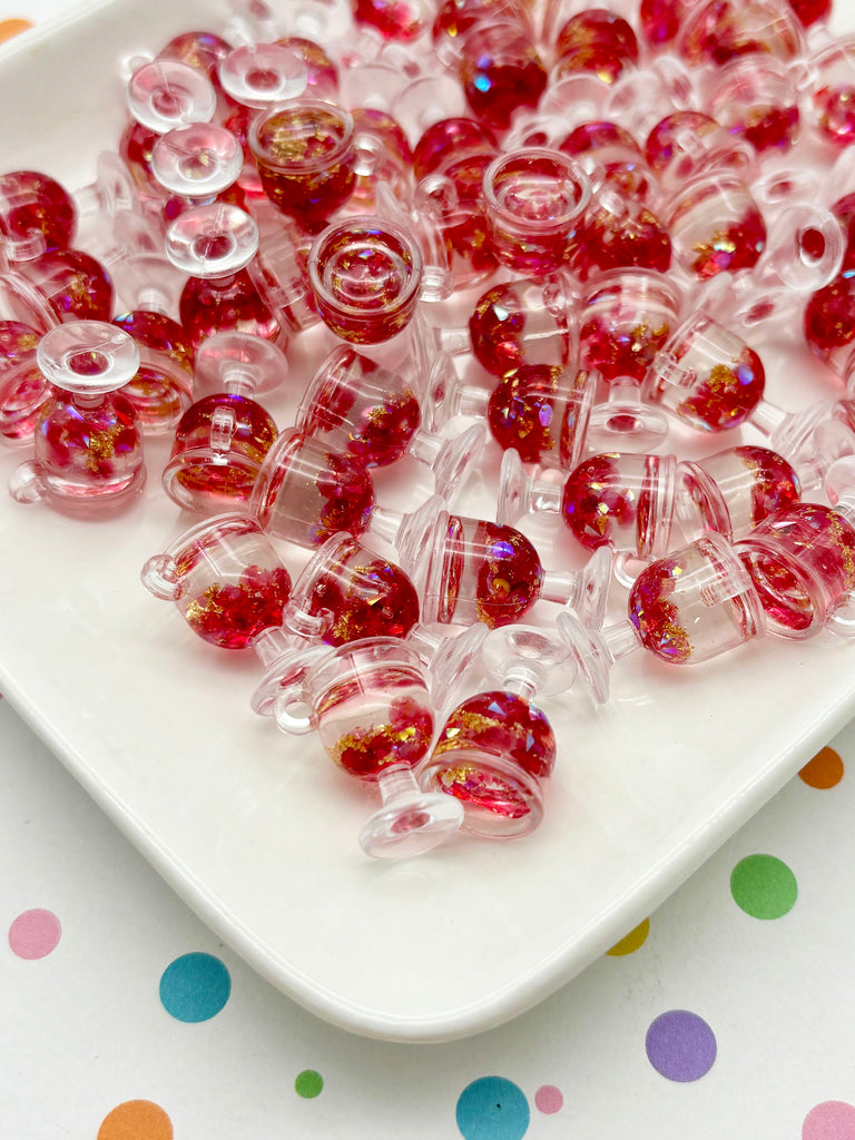 a white plate topped with lots of red glass beads