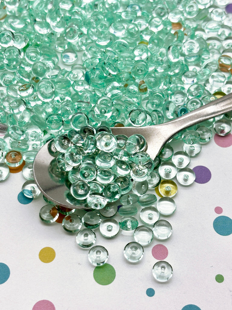 a spoon full of beads sitting on top of a table