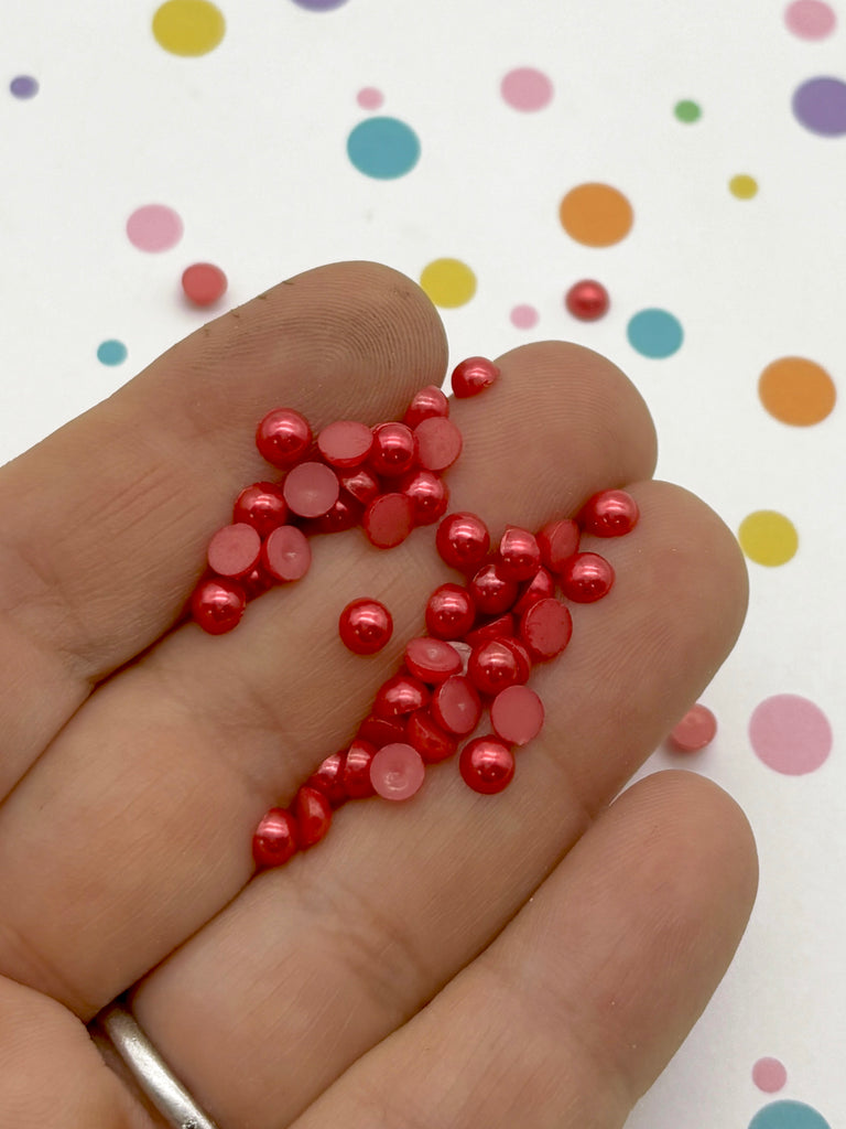 a hand holding a handful of red confetti