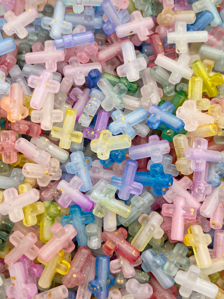 The image is a colorful assortment of small, multicolored beads or objects that appear to be made of plastic or glass, scattered together in a visually appealing manner.