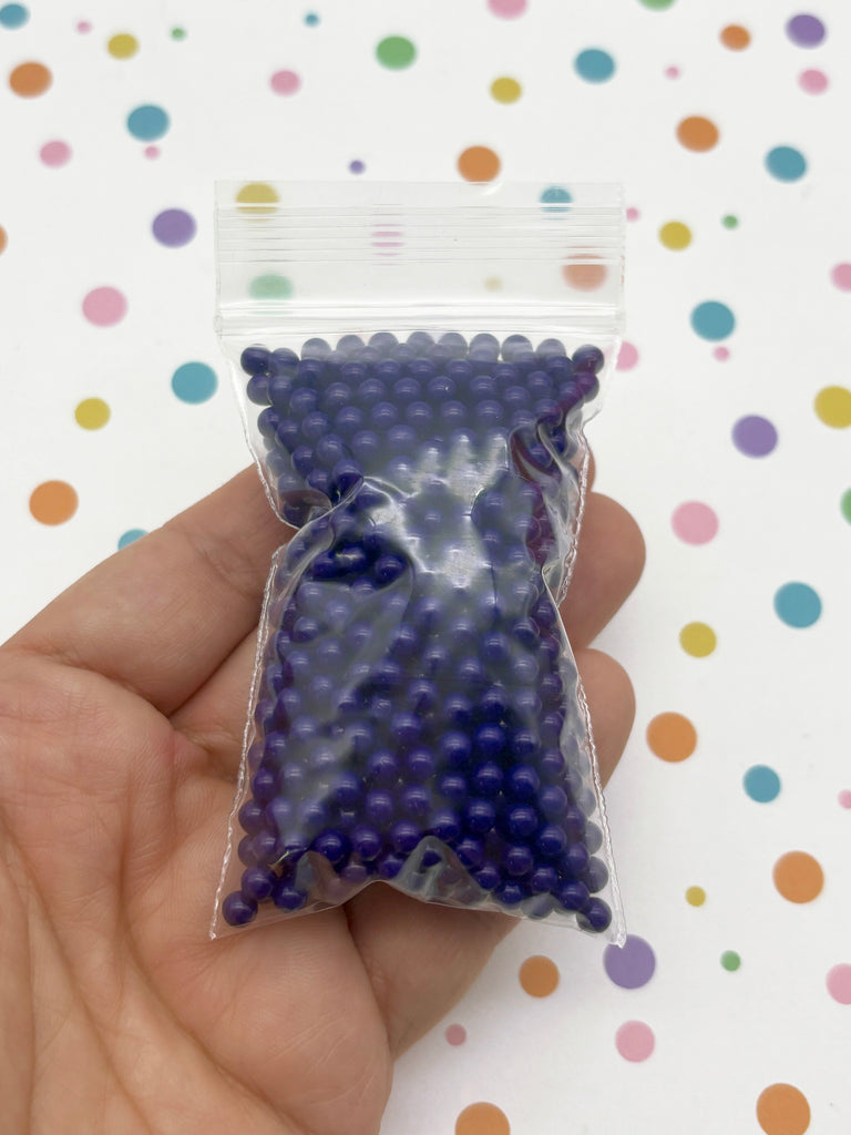 a hand holding a bag of blue and purple candy