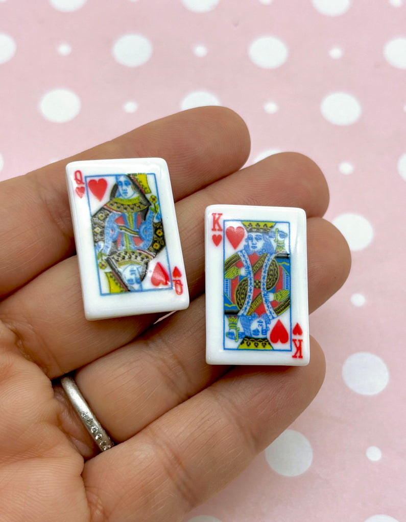 a person holding a pair of playing cards in their hand