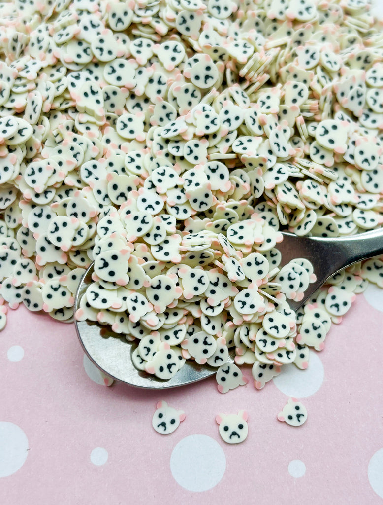 a spoon full of white and black polka dot cookies