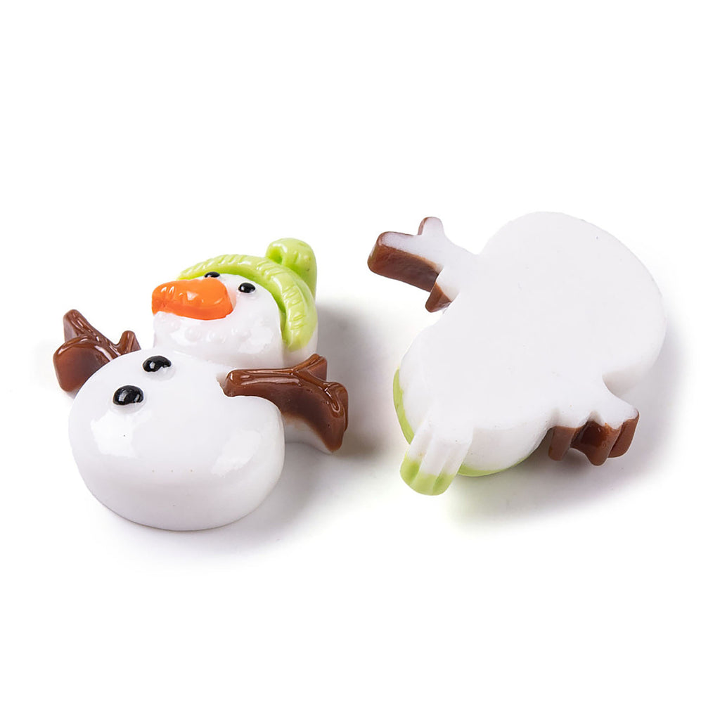 two snowman-shaped objects, one with a green hat and the other with a white body, both sitting on a white surface.