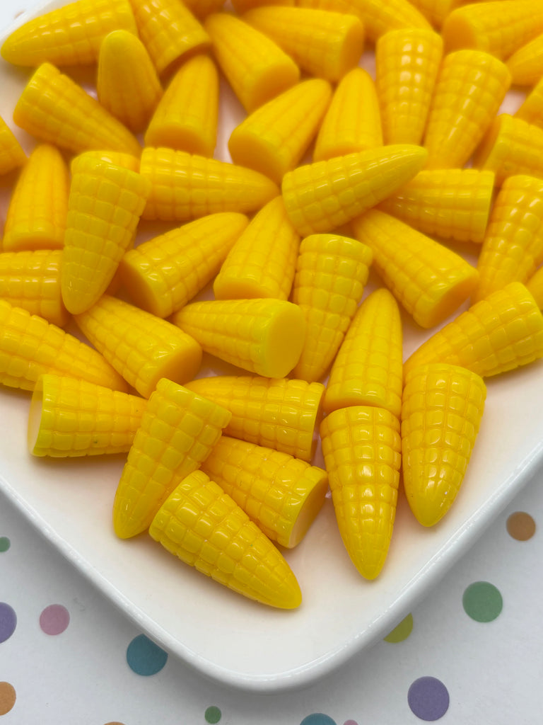 a white plate filled with yellow corn kernels, arranged in a visually appealing manner.