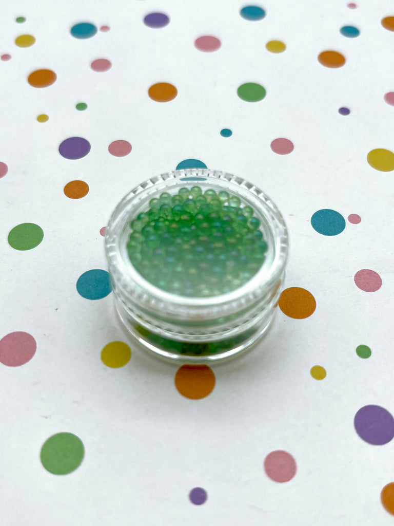 a jar of green glitter sitting on top of a table