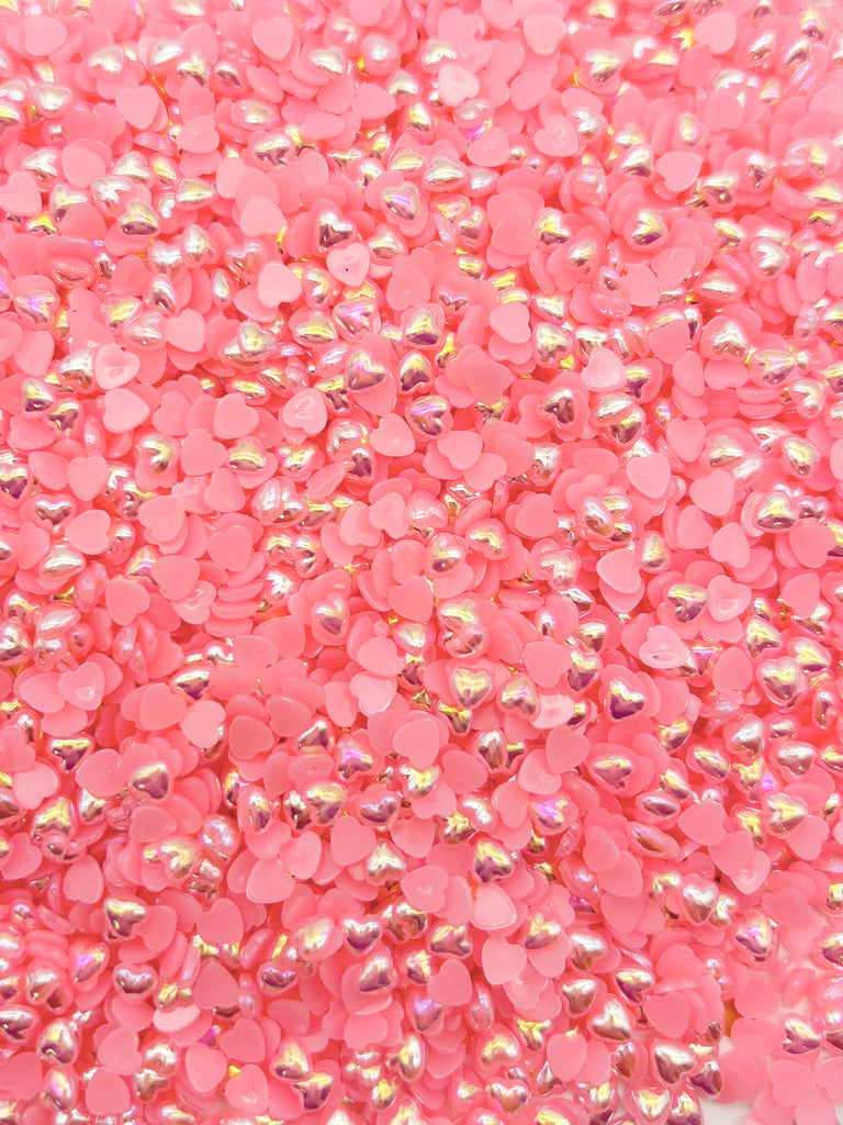 a pile of pink sequins on a white background