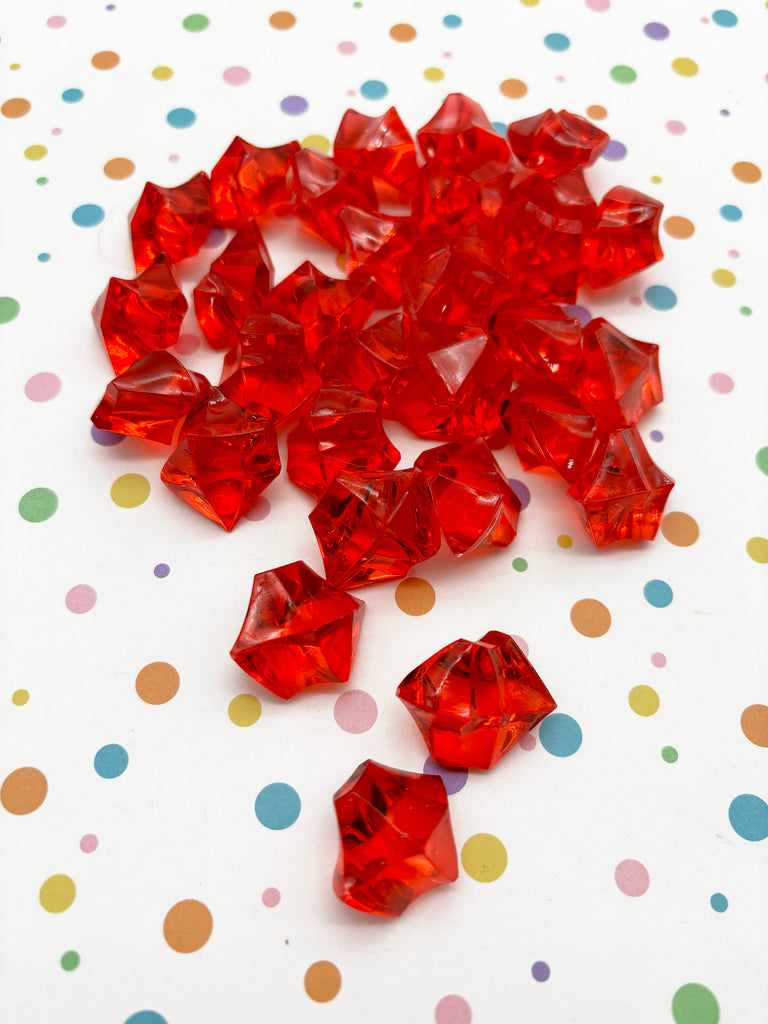 a pile of red crystals sitting on top of a table